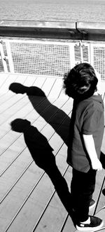 High angle view of boy standing on shadow