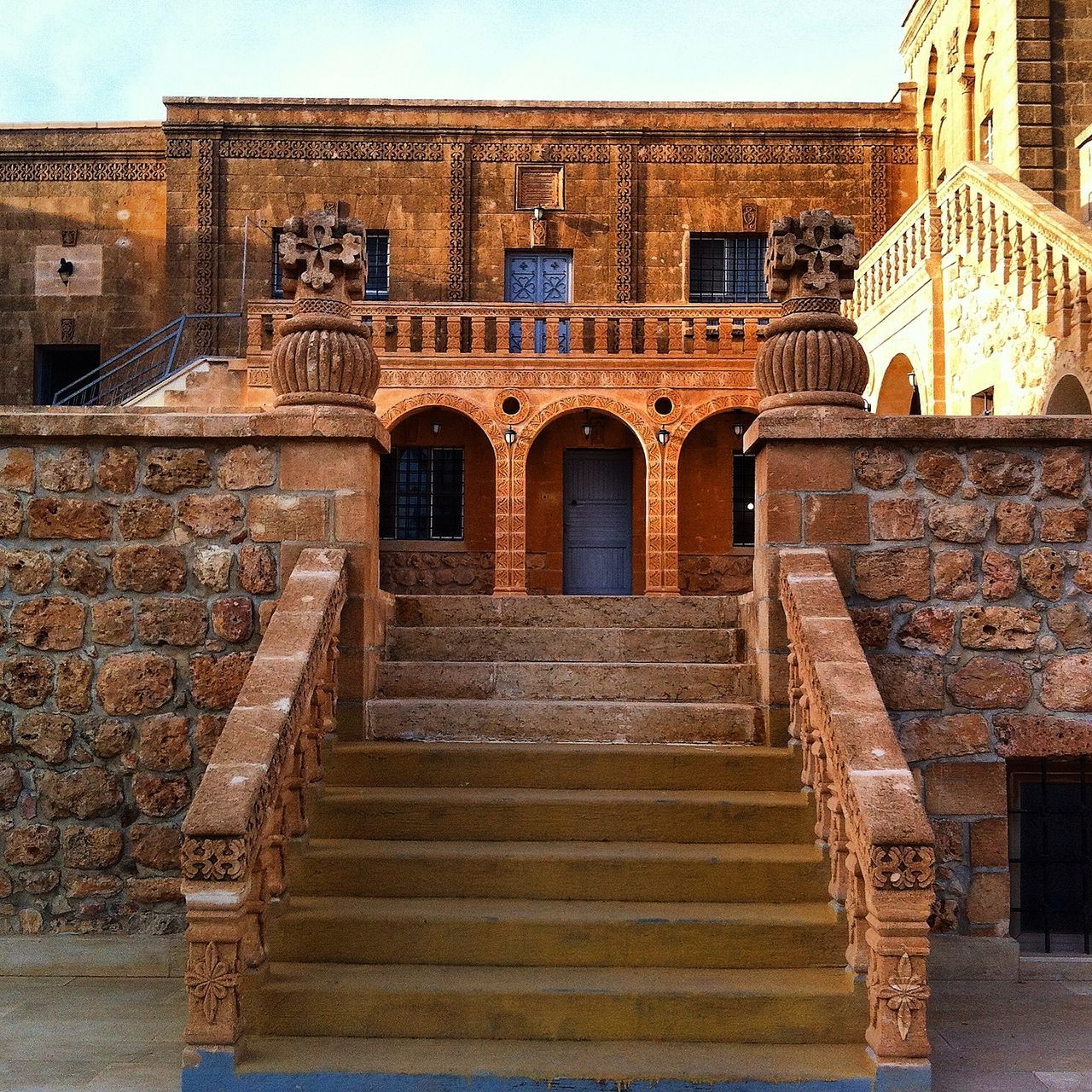 architecture, built structure, building exterior, steps, steps and staircases, history, low angle view, staircase, old, arch, building, entrance, brick wall, wall - building feature, day, clear sky, historic, outdoors, railing, architectural column