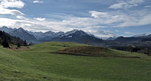 Scenic view of field and mountains against sky