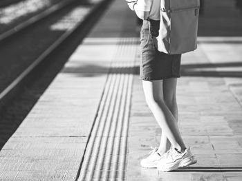 Low section of woman walking on footpath