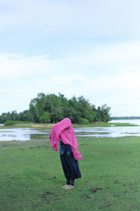 Rear view of woman on field against sky