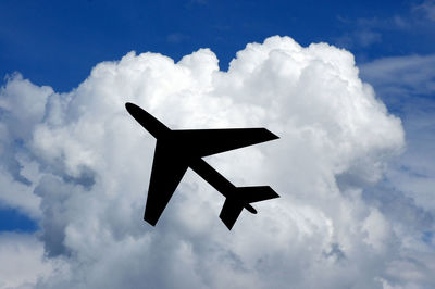 Low angle view of airplane against cloudy sky