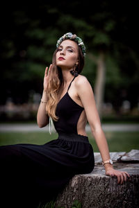 Young woman looking away while sitting outdoors