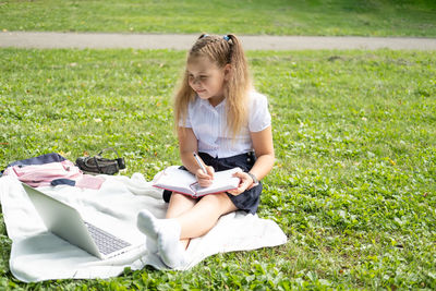 Portrait of young woman sitting on grass