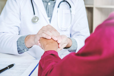 Midsection of doctor examining patient at hospital