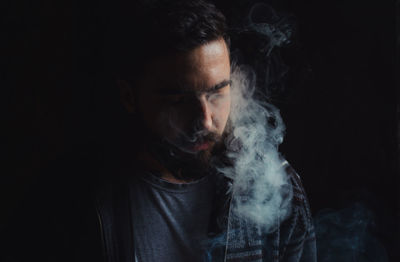 Portrait of young man smoking cigarette