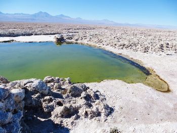Scenic view of lake amidst desert against sky