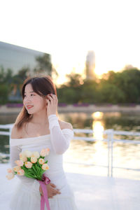 Portrait of young woman holding bouquet