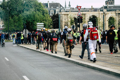 Group of people walking on road in city