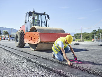 Worker marking roadside on construction site