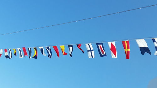 Low angle view of flags against clear sky