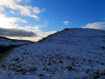 Scenic view of snowcapped mountains against blue sky