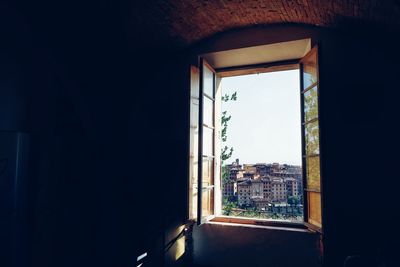 Buildings against sky seen through window