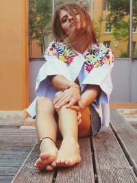 Full length of woman sitting outdoors