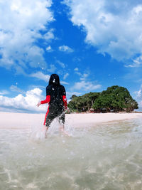 Rear view of man in sea against sky