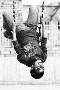 Close-up of happy boy playing on swing