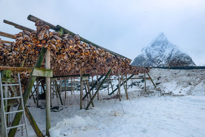 Built structure on snow covered field against sky