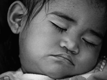 Close-up of baby sleeping on bed