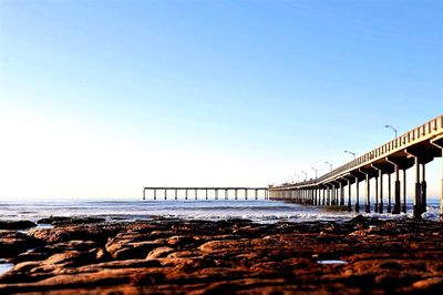 Bridge over sea against clear sky