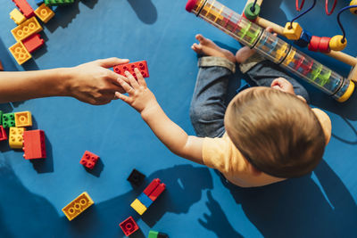 High angle view of people playing with toy on table