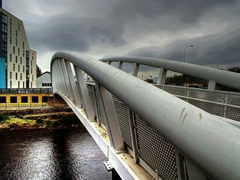 Bridge over river against cloudy sky