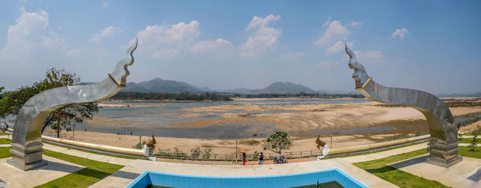 Panoramic view of people on mountain against cloudy sky