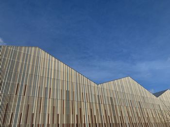 Low angle view of modern building against blue sky