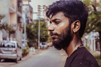 Profile view of man with beard in city