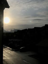 Street amidst buildings in city against sky during sunset