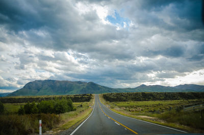 Empty road along landscape against sky