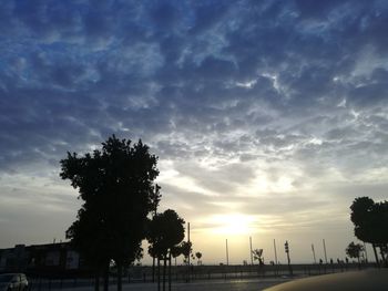 Low angle view of silhouette palm trees against cloudy sky