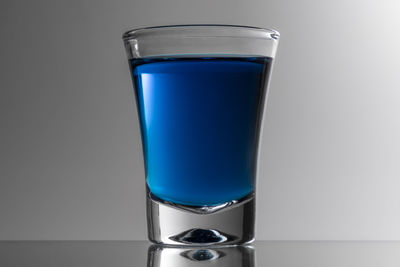 Close-up of blue glass against white background