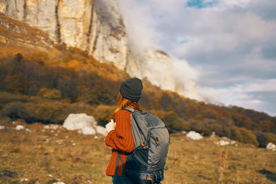 Rear view of man standing against mountain against sky