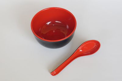 High angle view of red wine on table against white background