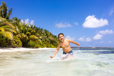 Portrait of shirtless man swimming in sea against sky