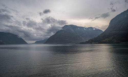 Scenic view of sea and mountains against sky