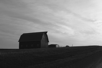 Barn on field against sky