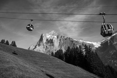 Low angle view of overhead cable car against sky