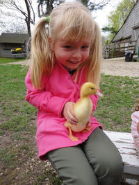 Close-up of girl with birds in park