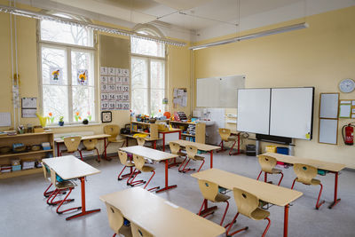 Interior of neat classroom with racks and furniture at school