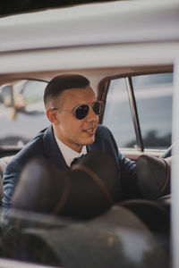 Man wearing sunglasses sitting in car