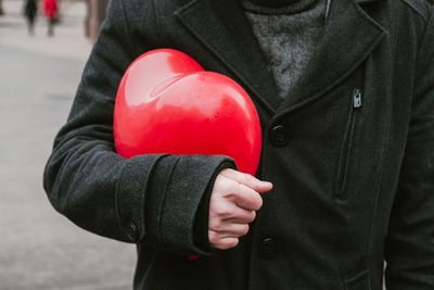 Midsection of man holding red umbrella