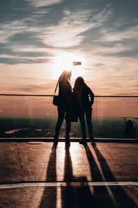 People standing on zebra crossing at sunset