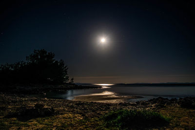 Scenic view of lake against clear sky at night