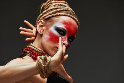 Side view of young woman against black background