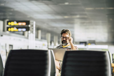 Mature man using laptop while sitting at airport
