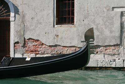 Graffiti on wall by boat moored in canal