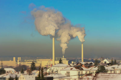 Smoke emitting from chimney against sky