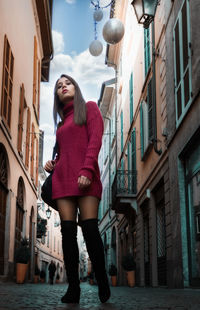 Woman standing by building in city