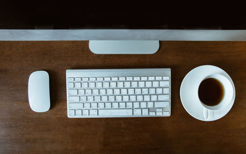 Directly above shot of computer and coffee cup on table